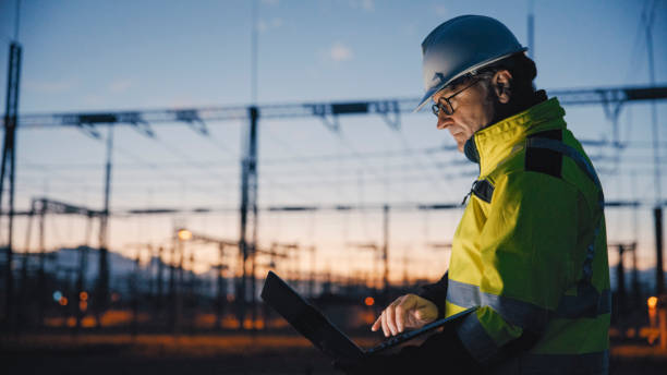 istock Side View Of Dedicated Electrical Engineer Using Laptop At Dark Power Plant During Twilight 1777966015