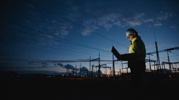 istock Determined Electrical Engineer Using Laptop On Silhouette Power Station At Twilight 1777966546