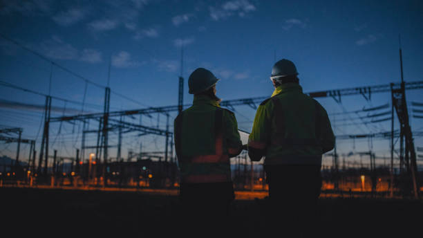 istock Rear View Of Dedicated Electrical Engineers Looking At Silhouette Transformers During Night 1777966599