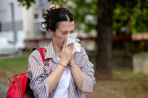 A young woman, eager for some fresh air and the joys of a public park, finds her plans thwarted as she's seized by repeated sneezing fits