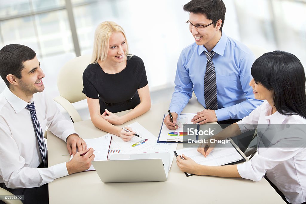 Happy business team having a meeting about data  Group of business people working together in an office Adult Stock Photo