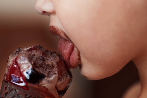 primo piano della bocca di un bambino che mangia un gelato al cioccolato - child chocolate ice cream human mouth foto e immagini stock