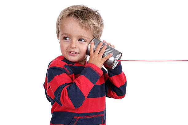 Tin can phone "Little boy listening through a tin can phone connected by string, concept for communication" toy phone stock pictures, royalty-free photos & images