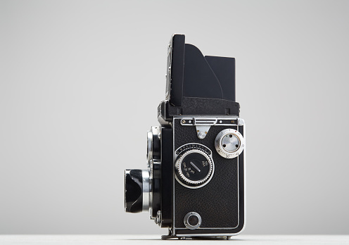 Vintage twin lens reflex camera with open viewfinder. Front view. Realistic retro design of medium format camera.