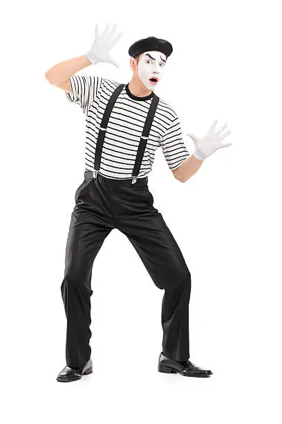 Full length portrait of a male mime artist performing, isolated on white background