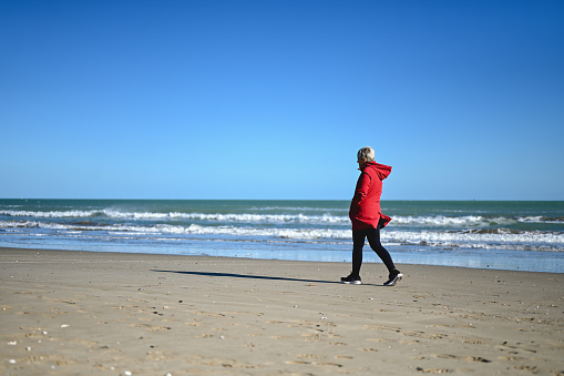 one person walking on an empty beach.