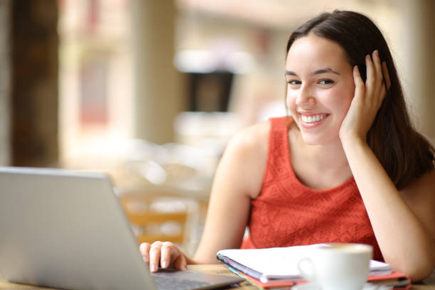 istock Happy student with notebook and laptop looks at you 1777987393