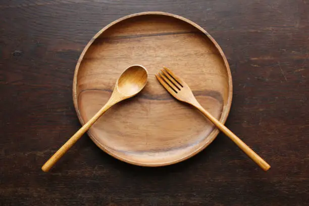 wooden plate, fork and spoon on the table