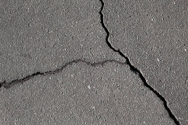 istock Closeup texture of damaged asphalt road surface with cracks 177799311