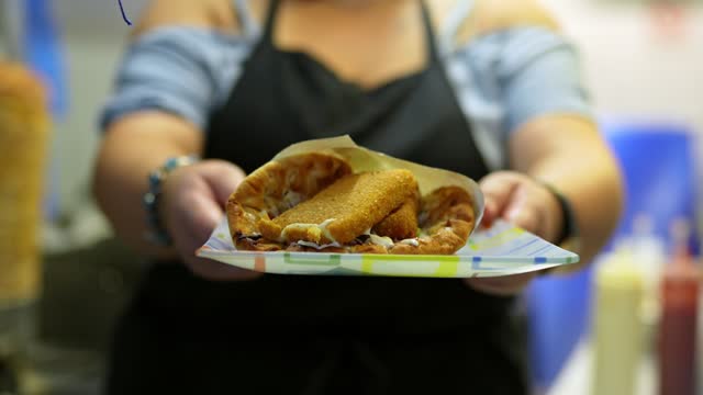 Food Service Worker Holding A Plate With Fried Cheese In Pita Bread At A Diner