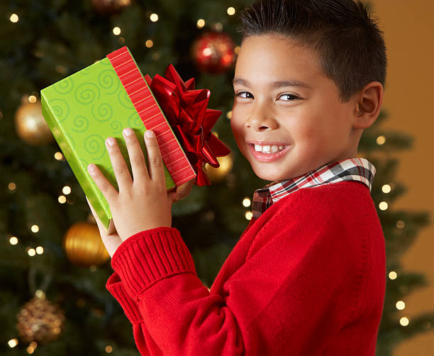 istock Boy Holding Christmas Present In Front Of Tree 177800497
