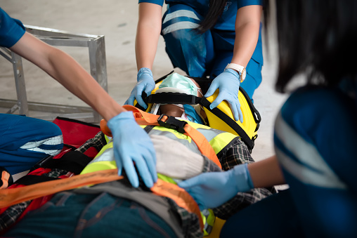 Patient lies on a stretcher in an ambulance, experienced paramedics put him on a drip