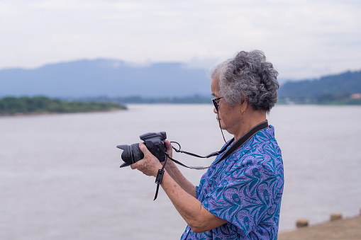 elderly man photographing his wife with a digital camera