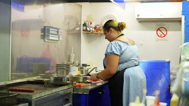 Food Service Worker Cutting Vegetables And Preparing Salad At A Diner