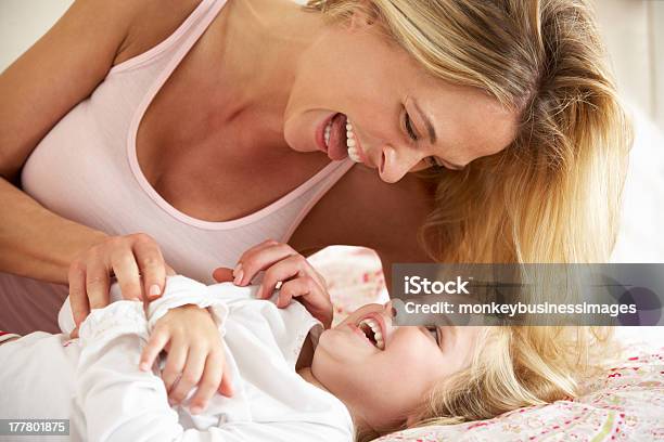 Mother And Daughter Relaxing Together In Bed Stock Photo - Download Image Now - Tickling, 30-39 Years, 4-5 Years