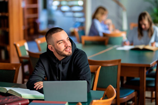 istock Confident male university student sitting in the library and studying 1778025179