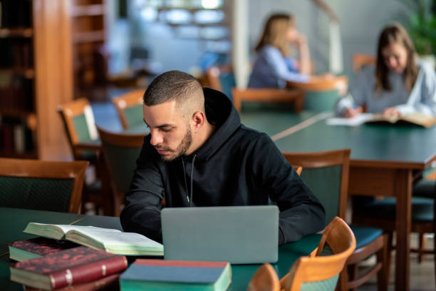istock Confident male university student sitting in the library and studying 1778025182