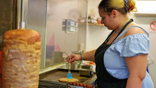 Food Service Worker Preparing Pita Bread For Gyros At A Diner