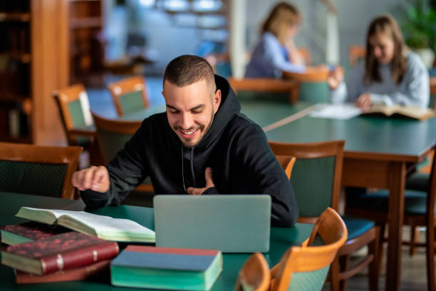 istock Young male student sitting in the university library and learning 1778027433