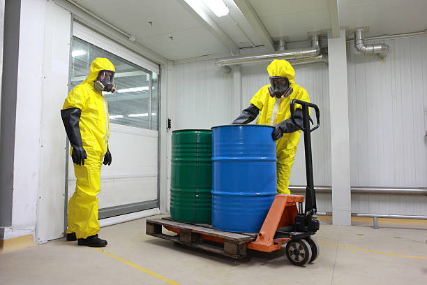 Two specialists dealing with barrels of chemicals stock photo