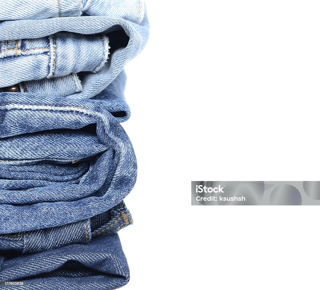 Stack of blue jeans Stack of jeans isolated on white At The Edge Of Stock Photo