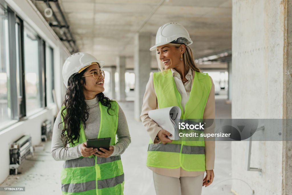 Inspecting construction site is our fav thing to do Two young architects visiting the  construction site and discussing varius issues 20-24 Years Stock Photo