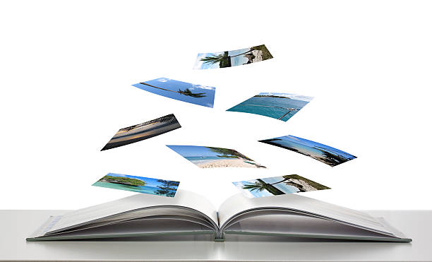 Photobook with Photos of Beach Scenes Floating Photobook concept with photos floating down onto book nostalgia photos stock pictures, royalty-free photos & images