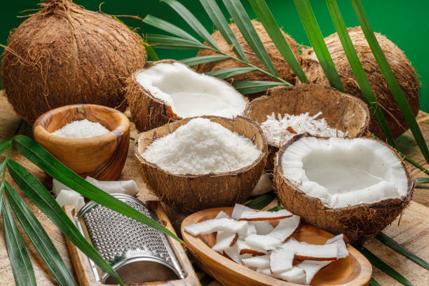 istock Fresh opened coconuts along with coconut slices, flakes and coconut leaves on a wooden table. Nice fruit background for your projects. 1778053078