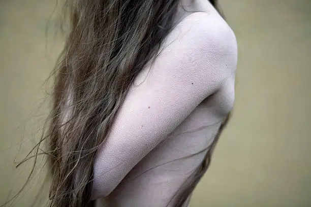 A photo of a feminine torso which perfectly shows her skin with goose bumps.