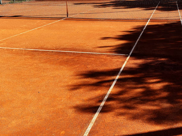 ampia vista del classico campo da tennis all'aperto arancione in terra battuta con rete, linee bianche - toughness surface level court tennis foto e immagini stock