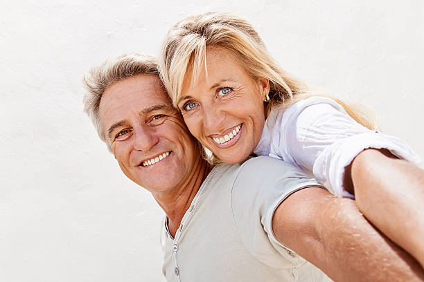 Mature couple smiling Portrait of a mature couple smiling and embracing. couple isolated wife husband stock pictures, royalty-free photos & images