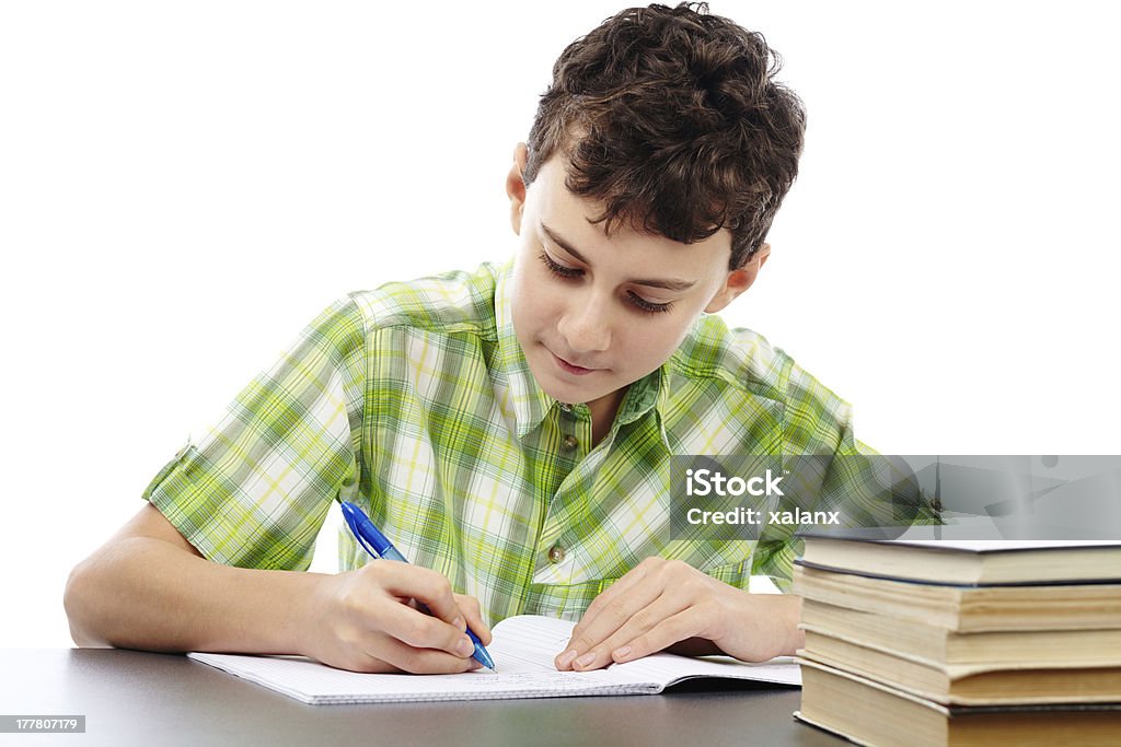 Student doing homework Caucasian student boy at his desk writing for homework Alertness Stock Photo