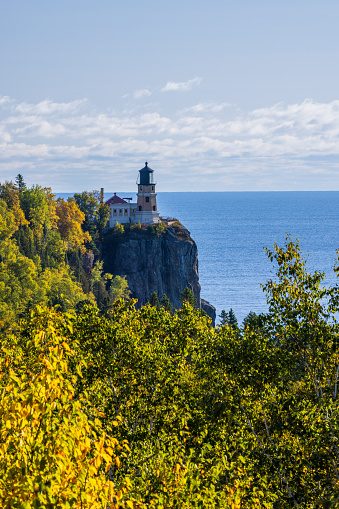 A lighthouse on a cliff along Lake Superior during autumn.