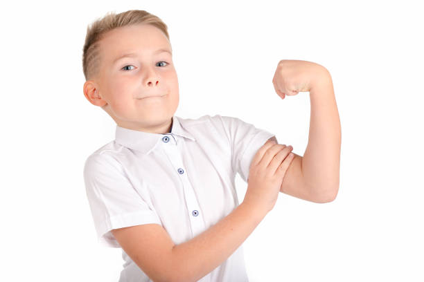 Close up image.The strong smiling caucasian school boy on a white background shows the force.
