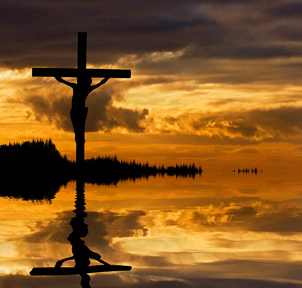 istock Jesus Christ Crucifixion silhouette reflected in lake water 177807628
