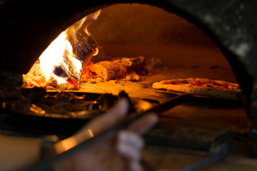 Pizza baking in wood oven.