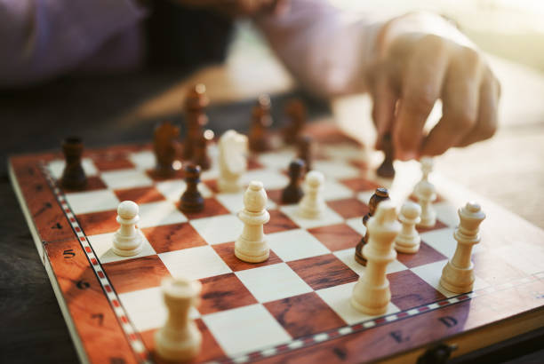 istock Hands, chess game and board with strategy in competition or challenge, intelligence and closeup of people playing. Thinking, planning and contest outdoor, concentration on boardgame and recreation 1778077387