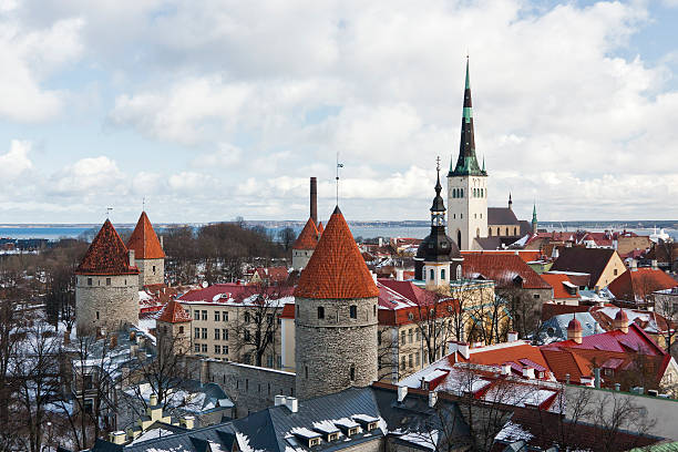 Old Town of Tallinn, Estonia historic Old Town of Tallinn, capital of Estonia. Roofs are covered with snow. Church St. Olaf (Oleviste) at background, curtain wall with towers in foreground. town wall tallinn stock pictures, royalty-free photos & images