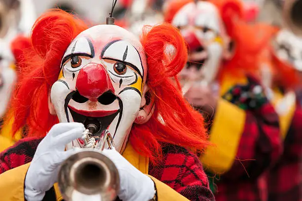Colorful clown group playing the trumpet at Basel fasnacht festival.