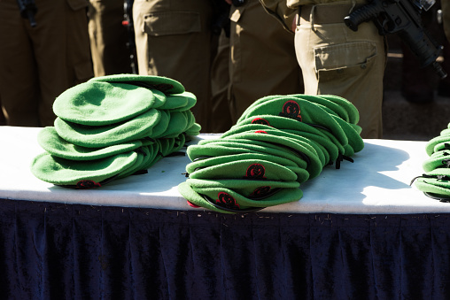 Green berets of the Nahal Brigade of the Israel Defense Forces stacked on a table during a special induction ceremony for new soldiers.