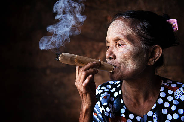 Old Asian woman smoking Old wrinkled Asian woman smoking traditional tobacco. Bagan, Myanmar. smokers wrinkles stock pictures, royalty-free photos & images