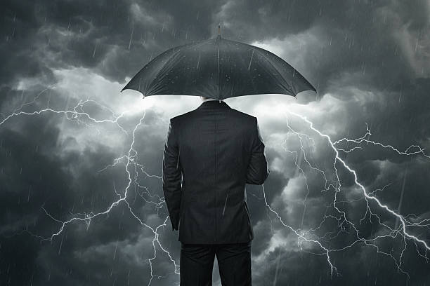 Trouble ahead concept Businessman with umbrella standing in the rain emergency shelter photos stock pictures, royalty-free photos & images