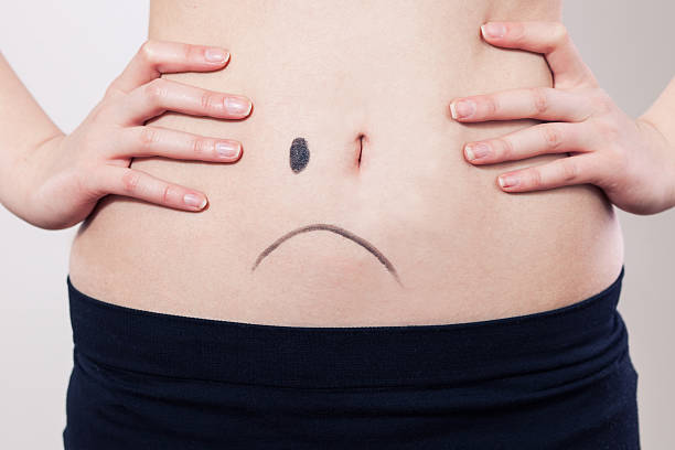 Woman's belly Woman's belly with sad face. female navel stock pictures, royalty-free photos & images