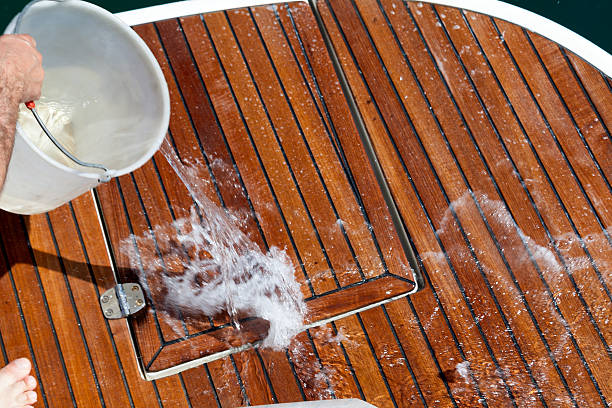 Washing The Deck Washing the deck with water throwed from a plastic buket. boat deck stock pictures, royalty-free photos & images