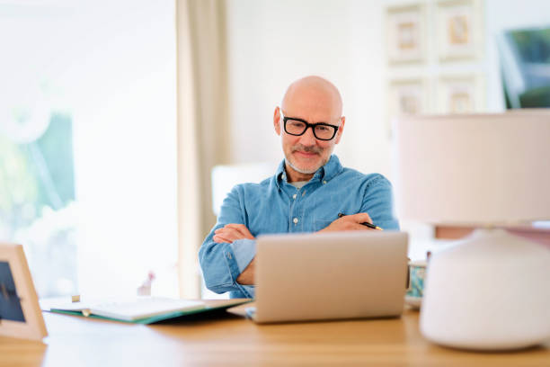 istock Mid aged man sitting at home and having web conference 1778107629