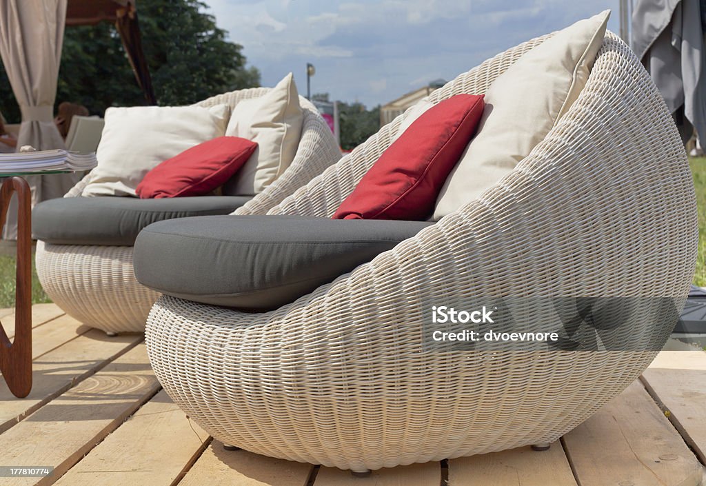 Two armchairs with colored pillows outdoors Soft wicker armchairs with color pillows outdoors. Horizontal shot Outdoors Stock Photo