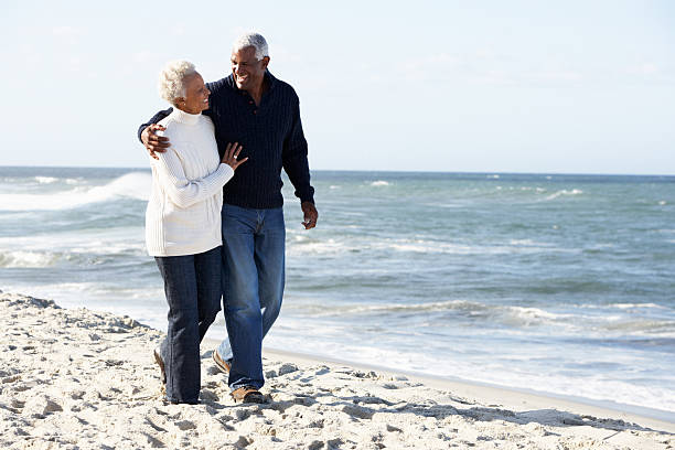 istock Senior Couple Walking Along Beach Together 177810796