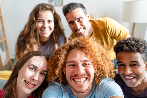 Portrait of group of friends laughing and having fun together at home
