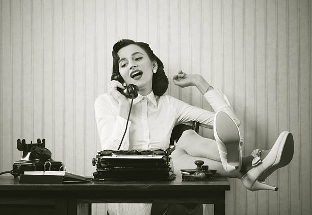 Woman talking on phone at desk Business woman puts her feet up on her desk on the phone typewriter photos stock pictures, royalty-free photos & images