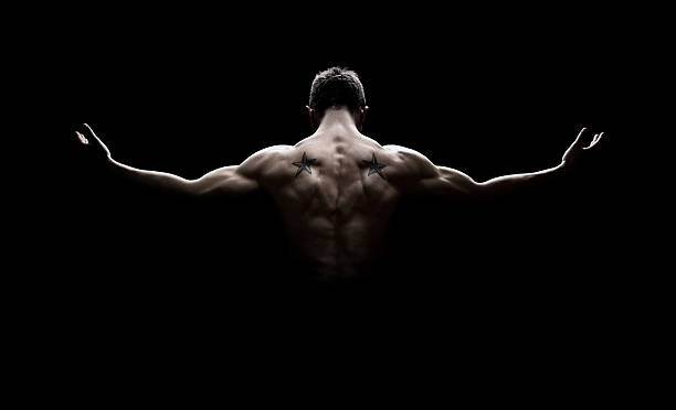 Perfect body Rear view of healthy young man with arms stretched out isolated on balck background human muscle photos stock pictures, royalty-free photos & images